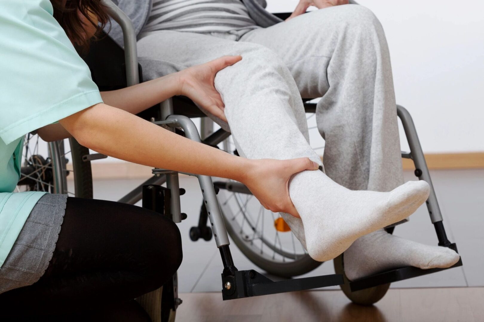 A person in a wheelchair with one foot on the ground.